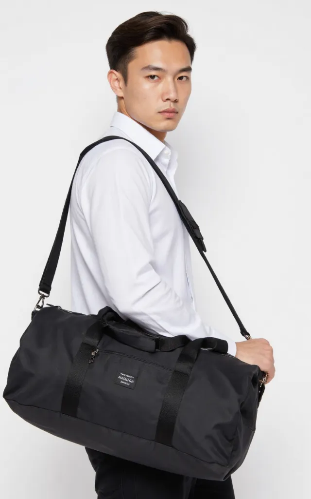 A French male model with a Polyester duffel bag, wearing a shirt, against a white background, in a front   facing close   up